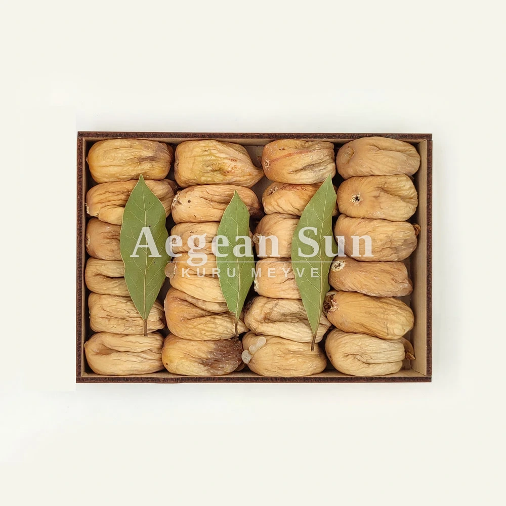 Whole dried figs packed in rows in a wooden box, with bay leaves laid between them